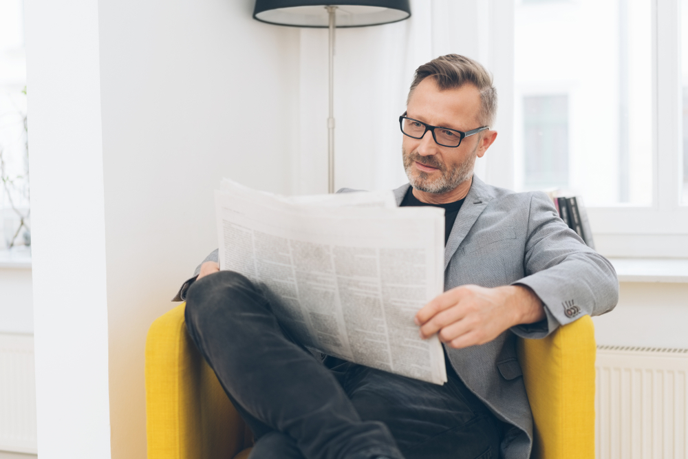 man reading a newspaper place an estate notice in the newspapers 