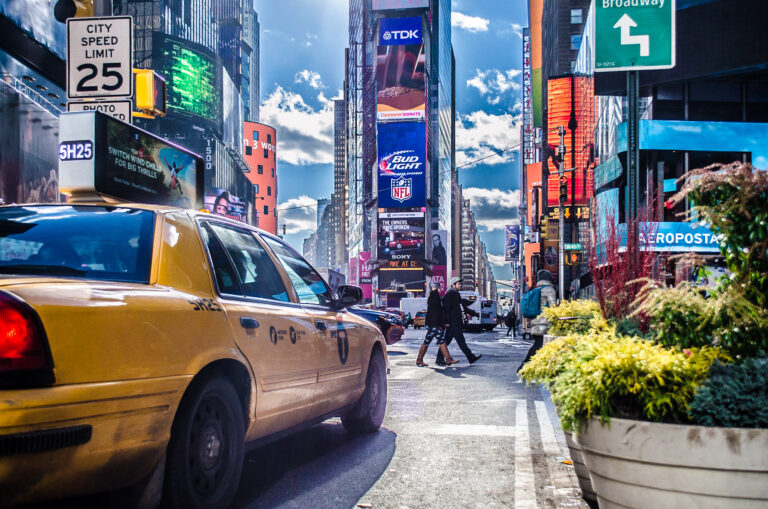 New York City, NY, USA - Jan 5th 2015: Manhattan Times Square View Behind a Yellow Cab. Beautiful District Full of LED Screens, Billboards and Advertisements. Advertise in the United States and Internationally.