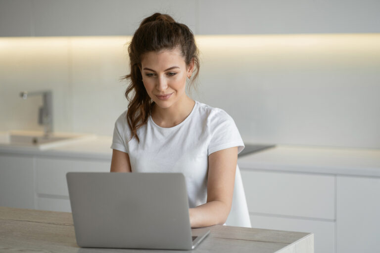 woman sitting at a computer looking up how to write a notice for bid