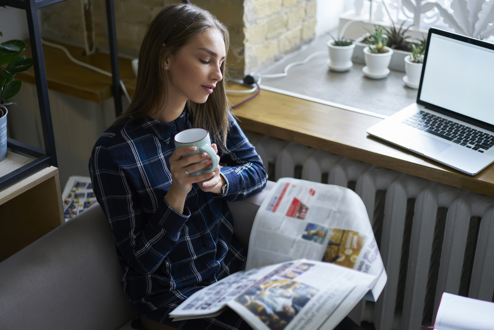 Woman reading a newspaper and drinking coffee. Place advertising Tampa or across Florida 