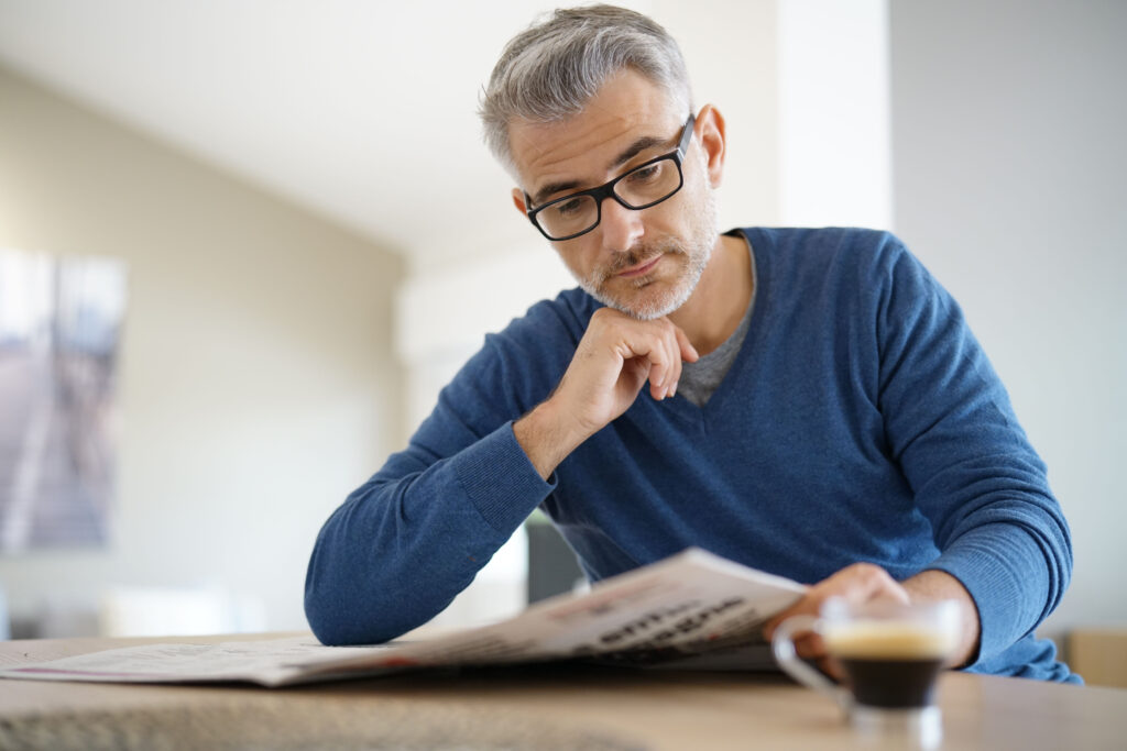 man reading a newspaper place run of paper advertising 