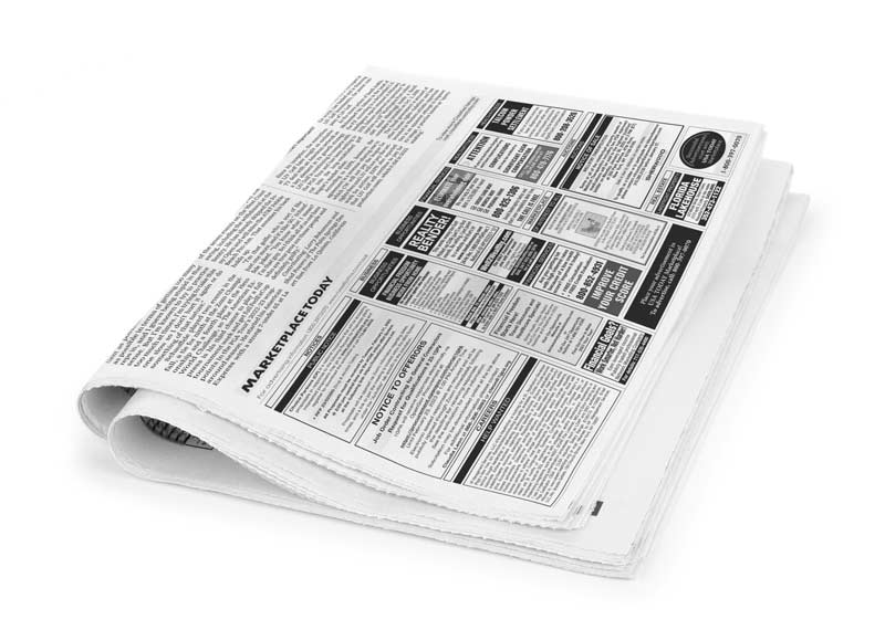 Newspaper laying on white background showing classified ads. Buy Classified Advertising in Print and Online