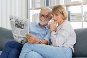 a couple reading the newspaper place discount advertising in classified and display and reach an affluent audience