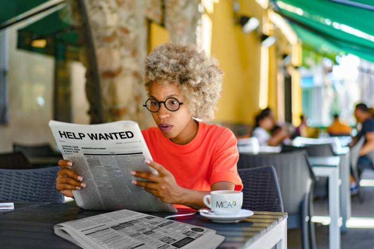 woman reading a newspaper outdoors Place Help Wanted Ads in Newspapers Nationally, Regionally, or by State