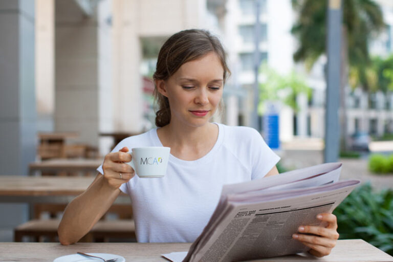 woman drinking coffee outdoors reading the newspaper place national classifieds and reach a diverse audience for economical prices